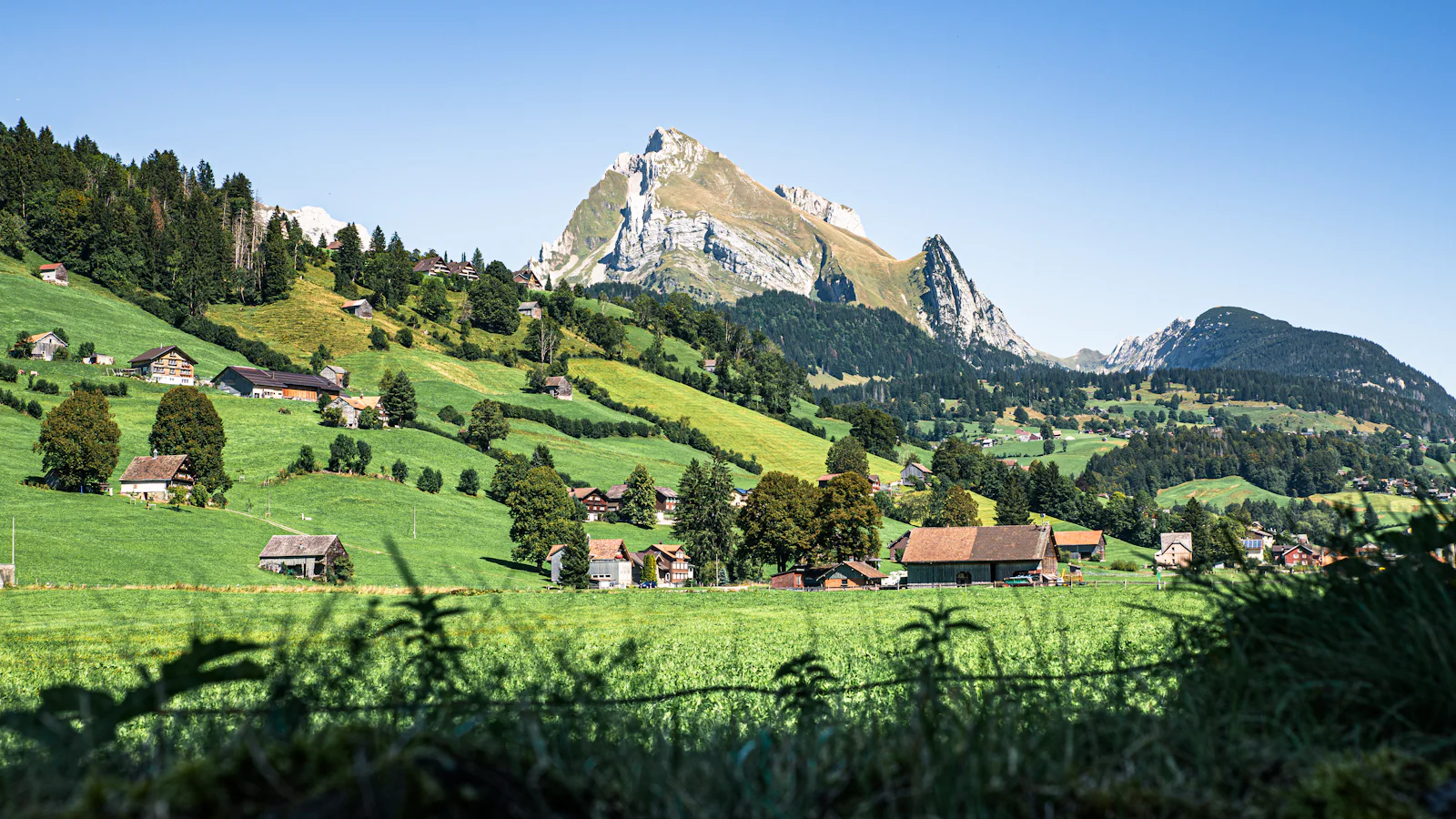 Bouteille d'huile d'olive et pain sur une table, un paysage suisse en arrière-plan
